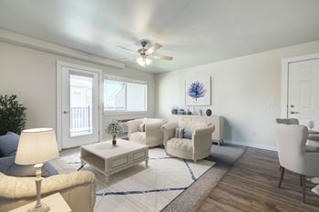 A living room with white furniture and a ceiling fan